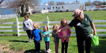Christine Jergeson points out something in the rain gardens to children.
