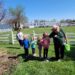 Christine Jergeson points out something in the rain gardens to children.