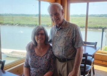 Woman and man in a restaurant by lake.