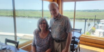 Woman and man in a restaurant by lake.