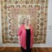 Woman standing in front of a quilt.