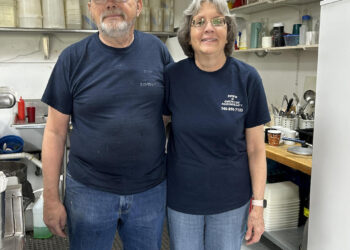 Two people in a restaurant kitchen.